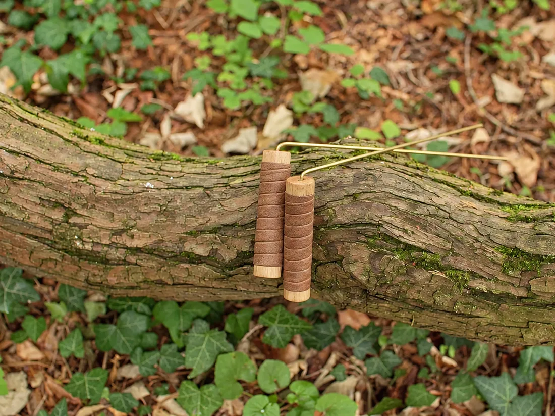 Une paire de Baguettes Sensitives posée sur une branche moussue.